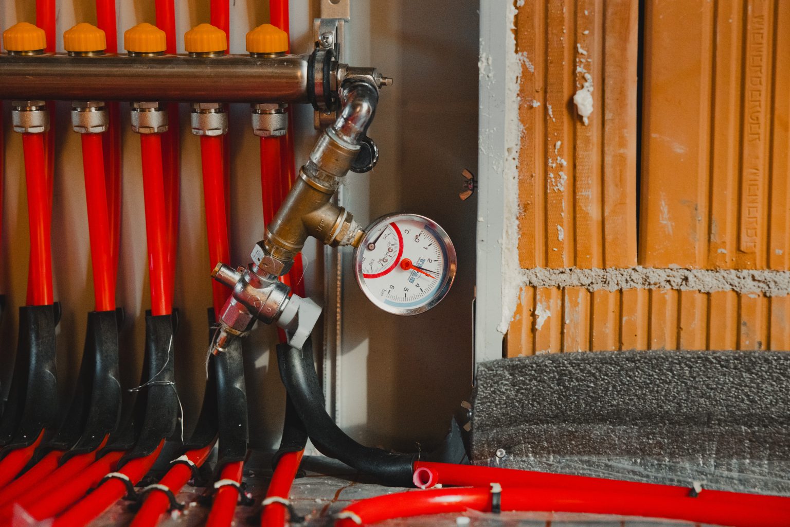 underfloor heating pipes and control panel being installed in new home construction